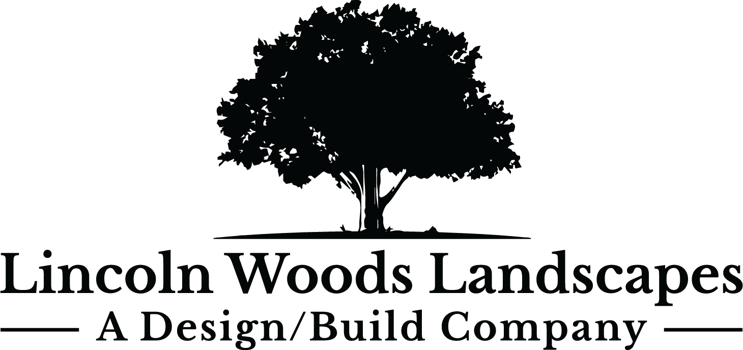 The image displays a logo featuring a tree silhouette, with the text "Lincoln Woods Landscapes – A Design/Build Company" in a dark color on a transparent background.